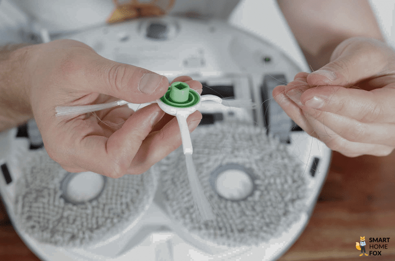 Die Seitenbürste des ECOVACS DEEBOT T20 OMNI wird von Haaren befreit.